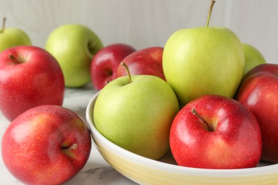 Photo of Ripe red and green apples on white marble table, closeup