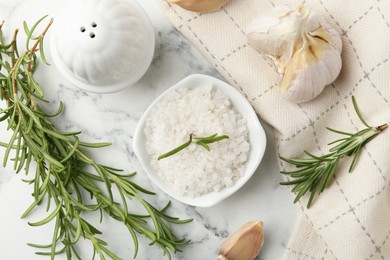 Photo of Sea salt, rosemary and garlic on white marble table, top view