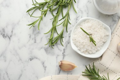 Photo of Sea salt, rosemary and garlic on white marble table, top view. Space for text