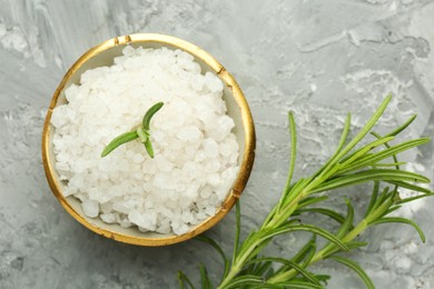 Photo of Sea salt and rosemary in bowl on gray textured table, flat lay