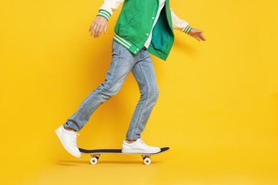 Photo of Man riding skateboard on orange background, closeup