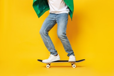 Photo of Man riding skateboard on orange background, closeup