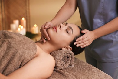 Photo of Woman receiving face massage in spa salon