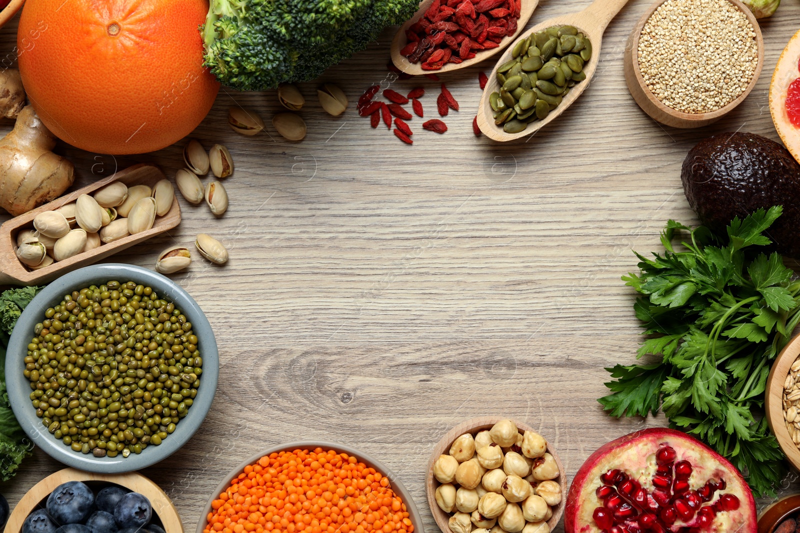 Photo of Frame of different superfood products on wooden table, flat lay. Space for text