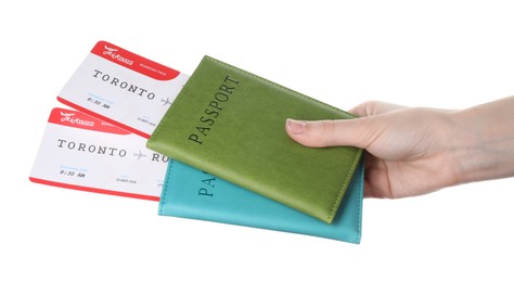 Photo of Travel agency. Woman holding flight tickets and passports on white background, closeup