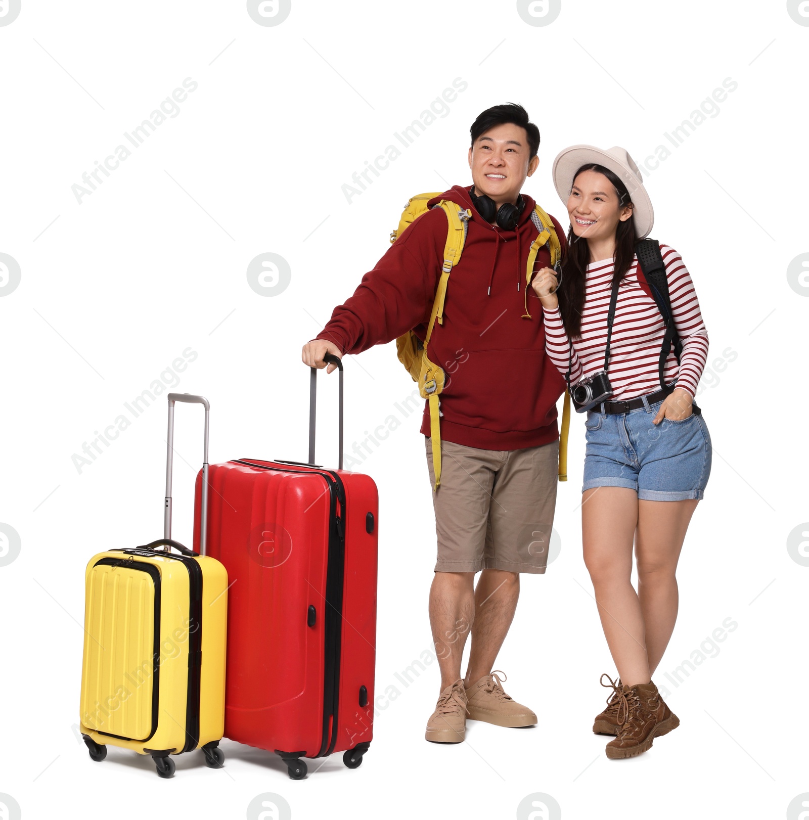 Photo of Happy travellers with suitcases on white background