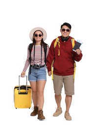 Photo of Happy travellers with passports and suitcase on white background