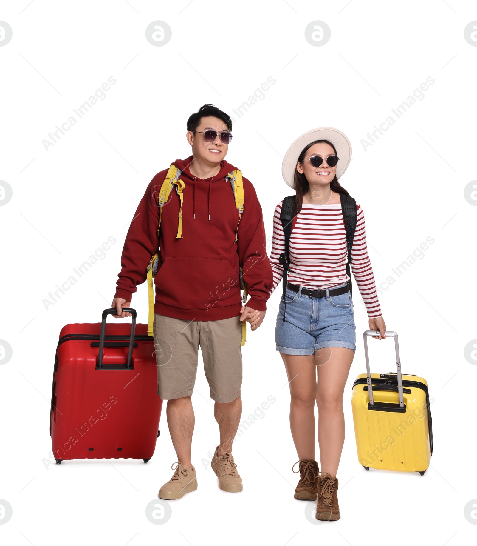 Photo of Happy travellers with suitcases on white background