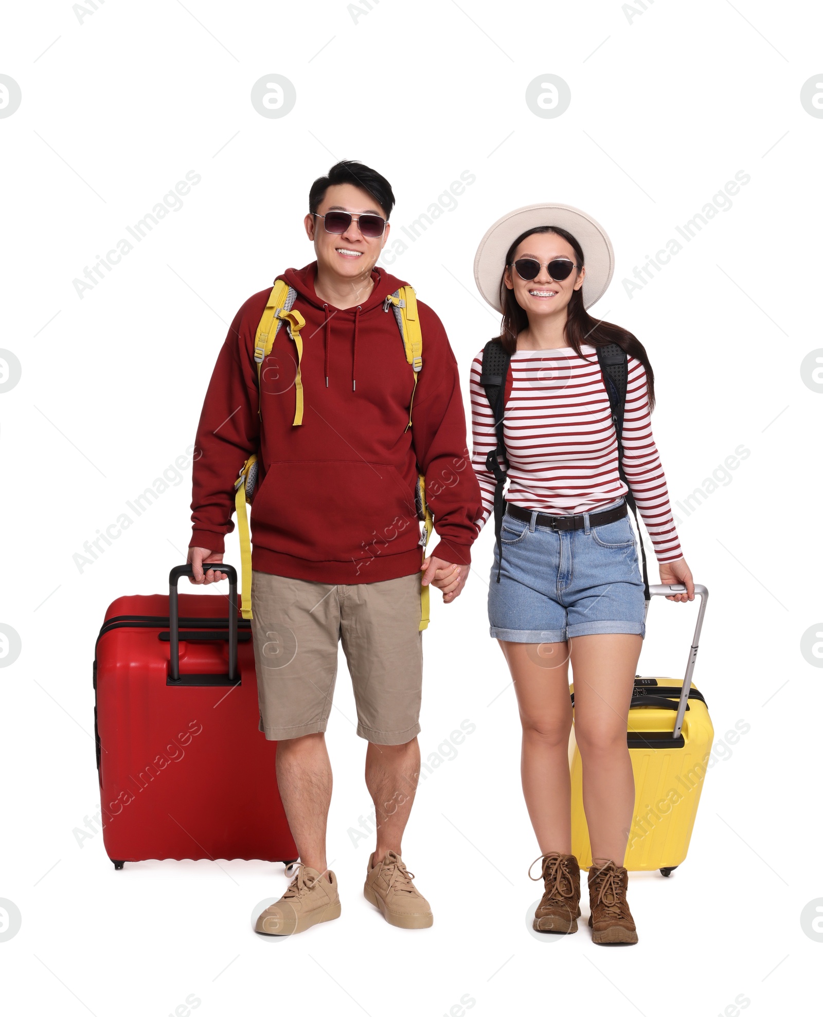 Photo of Happy travellers with suitcases on white background