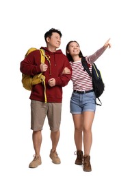 Photo of Happy travellers pointing at something on white background