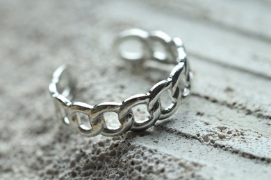 Photo of Beautiful silver ring on stone surface, closeup