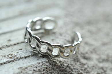 Photo of Beautiful silver ring on stone surface, closeup