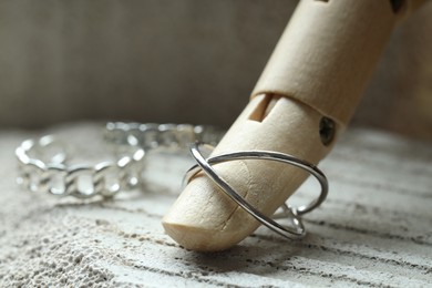 Beautiful silver rings and mannequin hand on stone surface, closeup