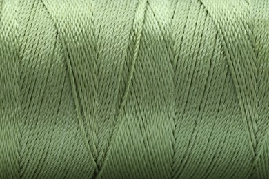 Photo of Beautiful olive sewing thread as background, closeup