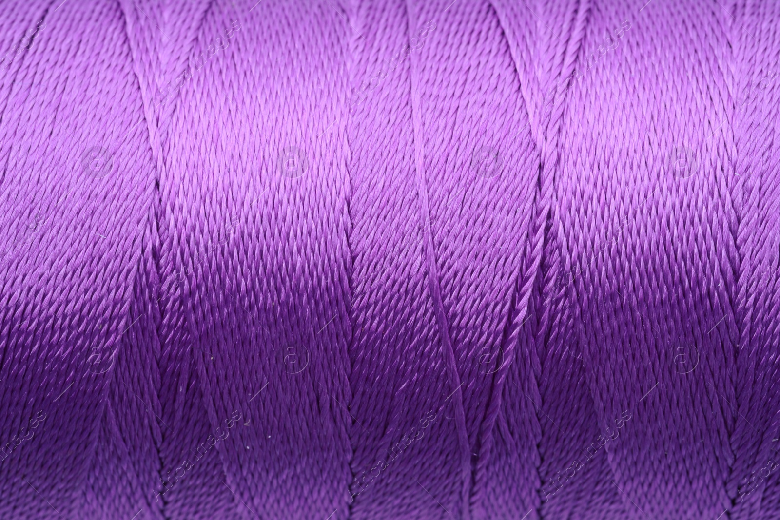 Photo of Beautiful purple sewing thread as background, closeup