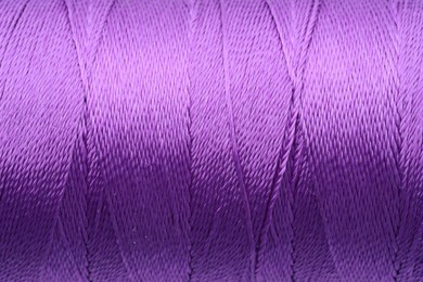 Photo of Beautiful purple sewing thread as background, closeup