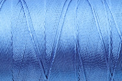 Photo of Beautiful blue sewing thread as background, closeup