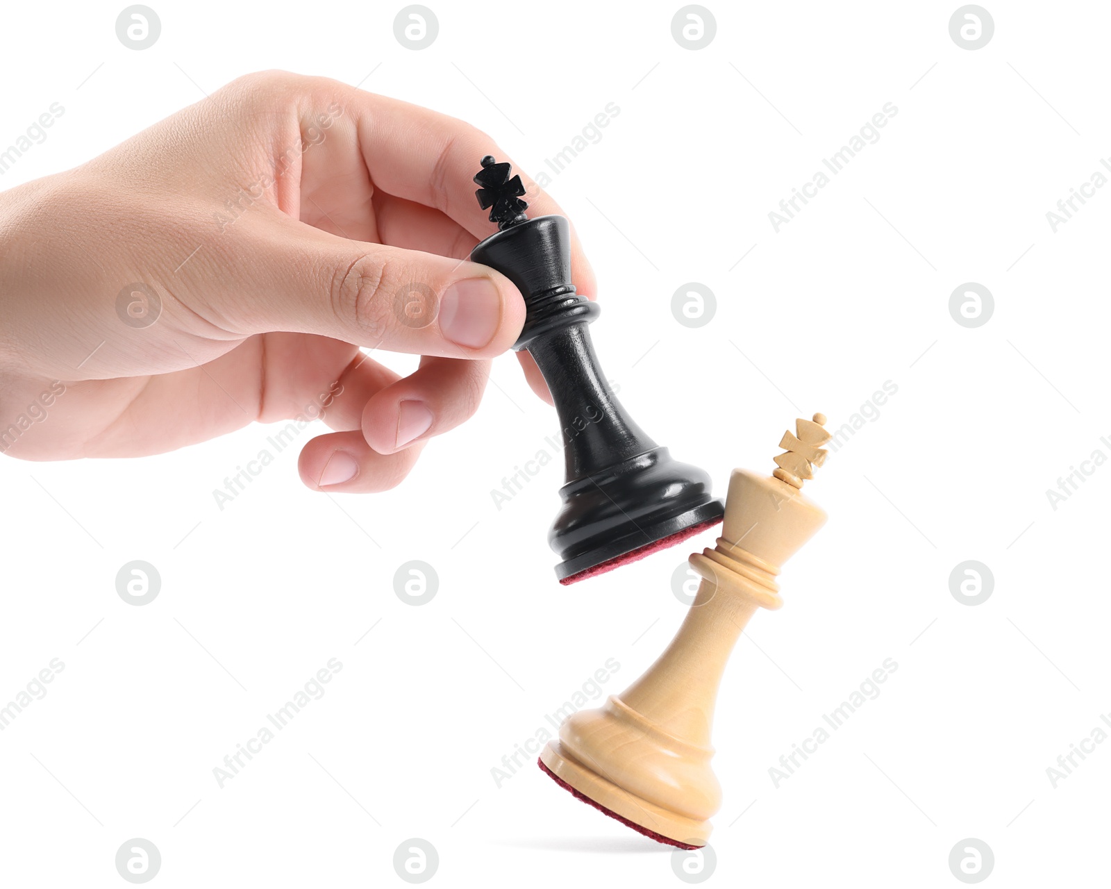 Photo of Man with black chess king knocking over white one on white background, closeup. Competition concept