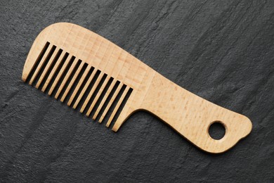 Photo of One wooden hair comb on grey background, top view