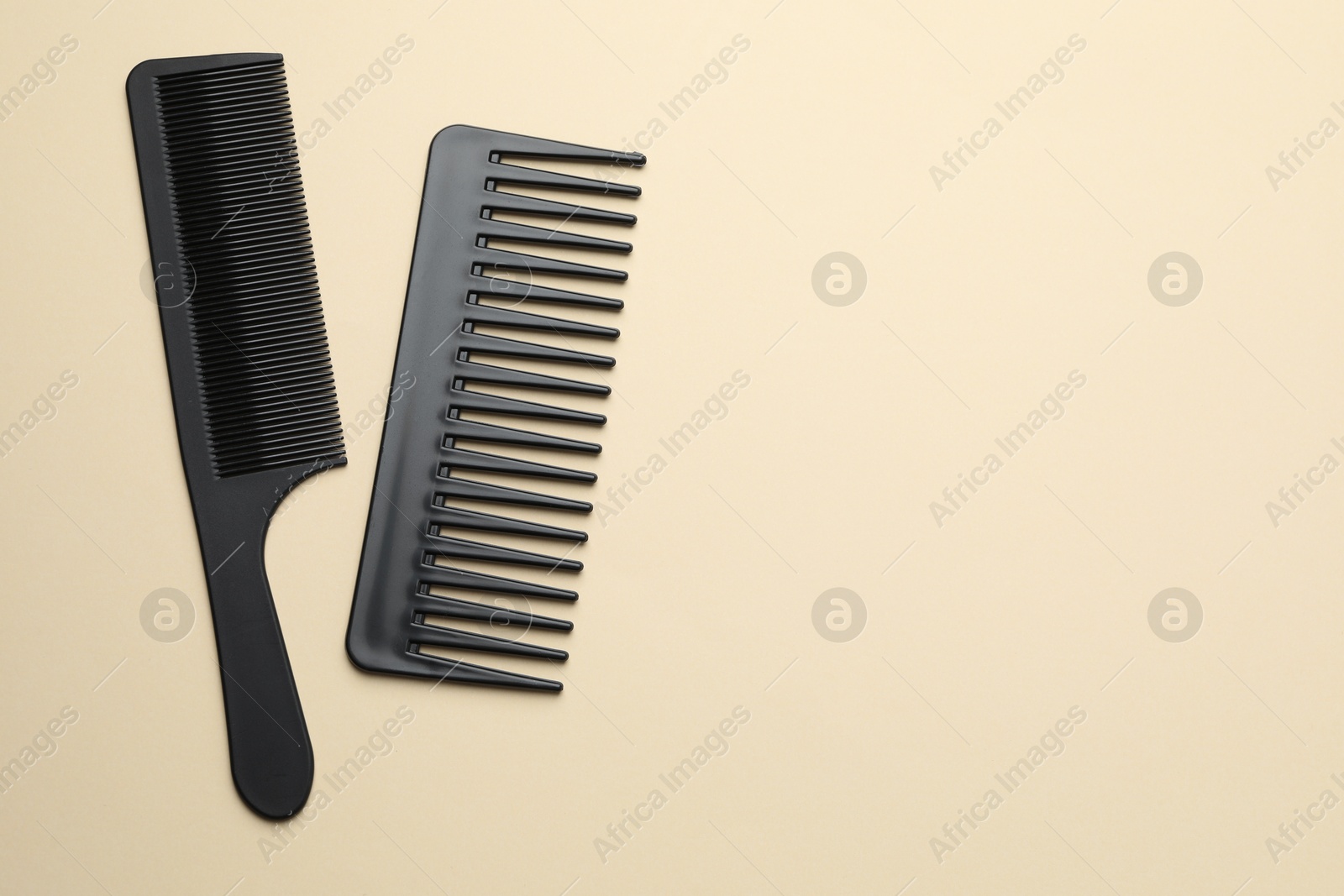 Photo of Different black plastic combs on beige background, top view. Space for text