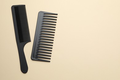 Different black plastic combs on beige background, top view. Space for text