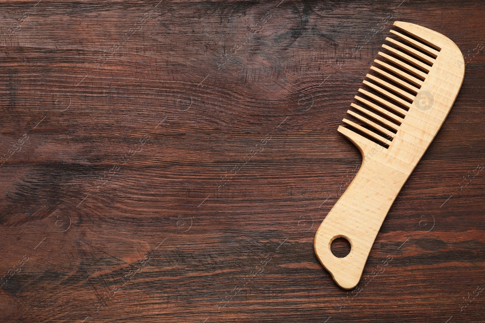 Photo of One hair comb on wooden background, top view. Space for text