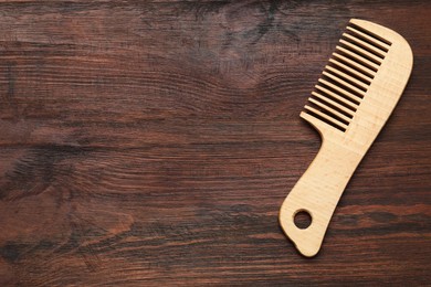 Photo of One hair comb on wooden background, top view. Space for text