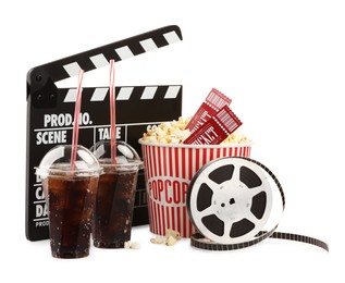 Photo of Tasty popcorn, film reel, clapper, soda drinks and movie tickets isolated on white