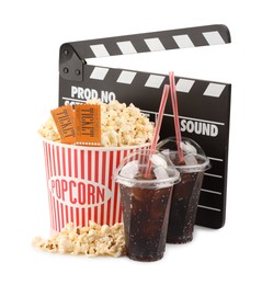 Photo of Tasty popcorn, drinks, clapper and movie tickets isolated on white