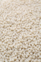 Photo of Pile of plastic granules as background, closeup