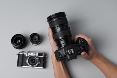 Photo of Photographer with professional camera on grey background, top view