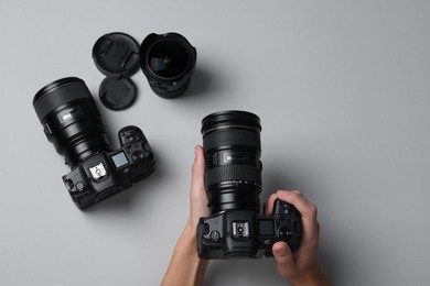 Photo of Photographer with professional camera on grey background, top view