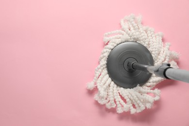 Photo of Mop with metal handle on pink background, top view. Space for text