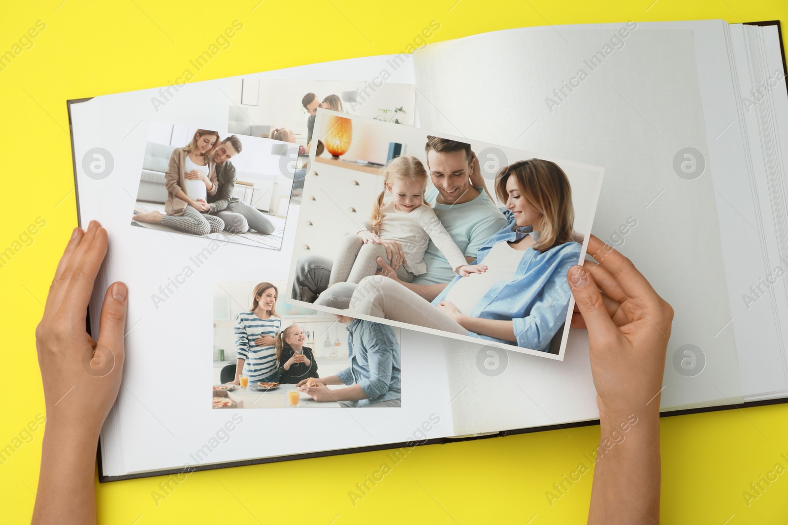 Photo of Woman with open photo album and different photos on yellow background, top view