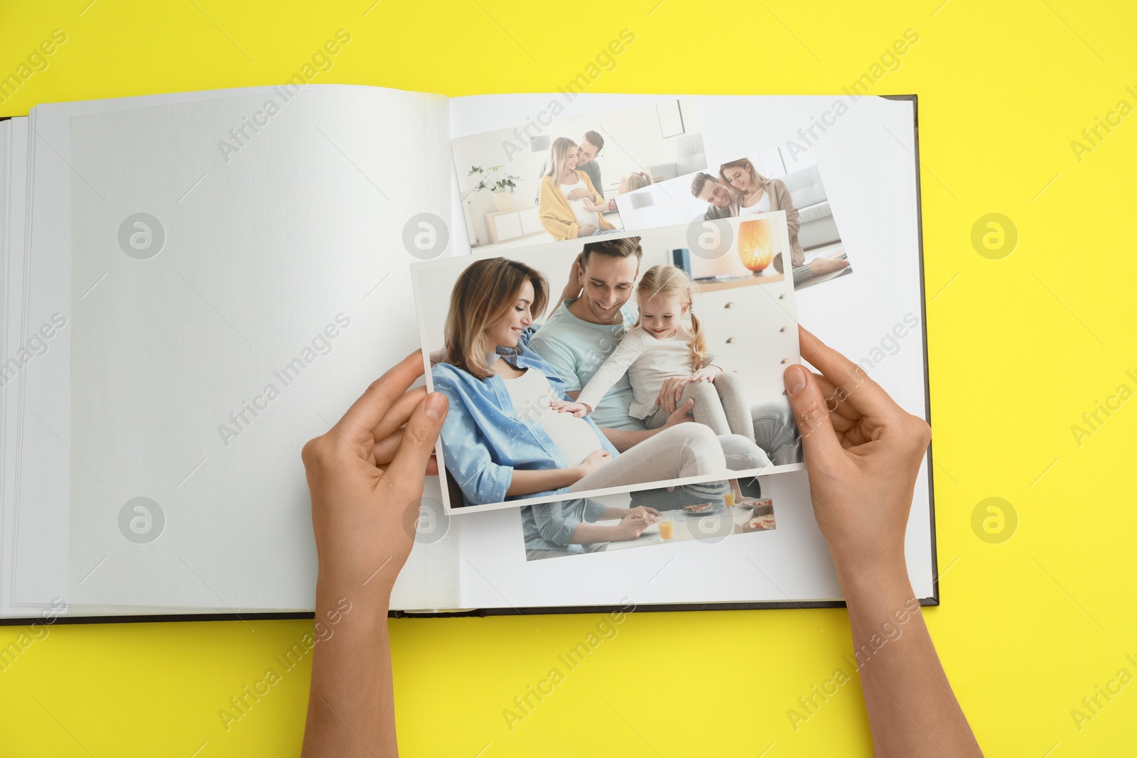 Photo of Woman with open photo album and different photos on yellow background, top view