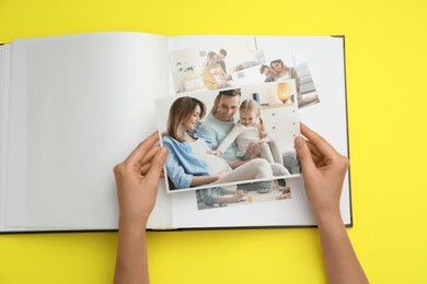 Photo of Woman with open photo album and different photos on yellow background, top view