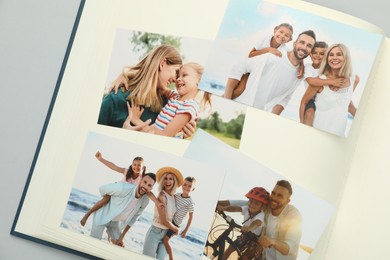 Photo of Open photo album with different photos on grey background, top view