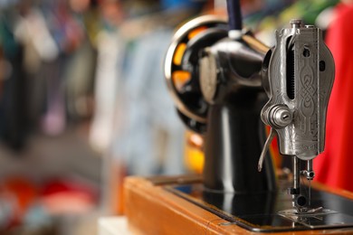 Photo of One vintage sewing machine in workshop, closeup. Space for text