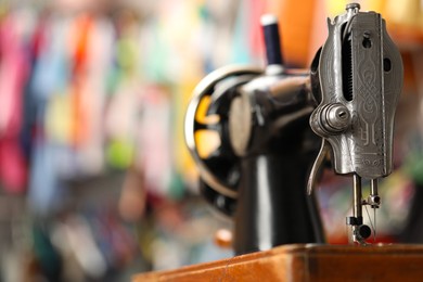 Photo of One vintage sewing machine in workshop, closeup. Space for text