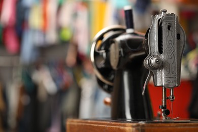 Photo of One vintage sewing machine in workshop, closeup. Space for text