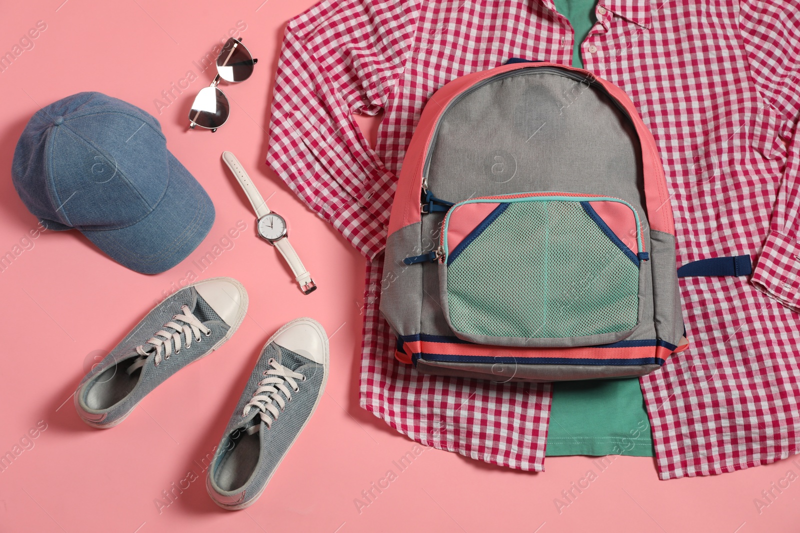 Photo of Stylish outfit with backpack on pink background, flat lay