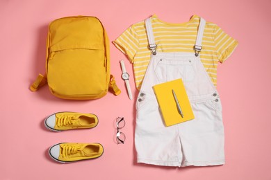 Photo of Stylish outfit with backpack on pink background, flat lay