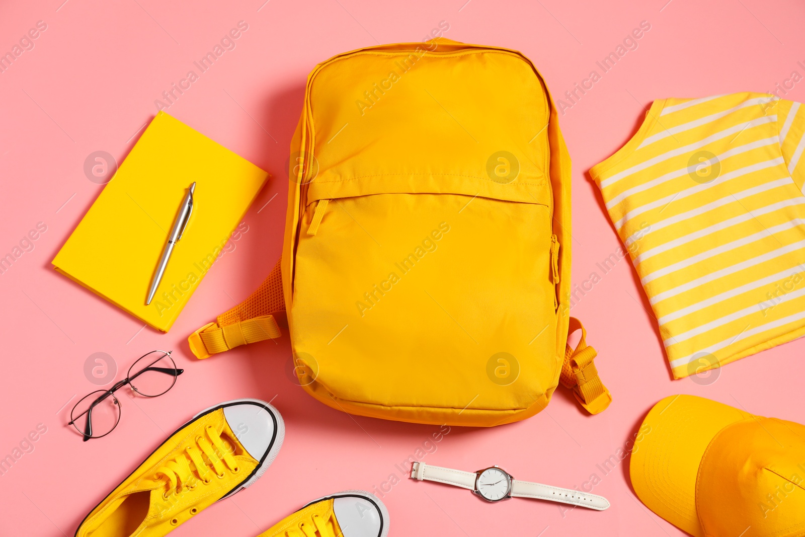 Photo of Stylish outfit with backpack on pink background, flat lay