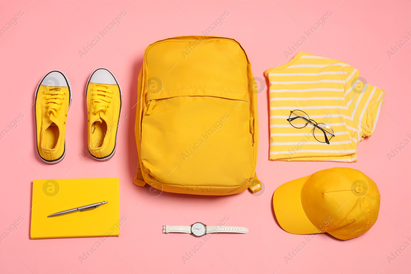 Photo of Stylish outfit with backpack on pink background, flat lay