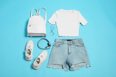 Photo of Stylish outfit with backpack on light blue background, flat lay