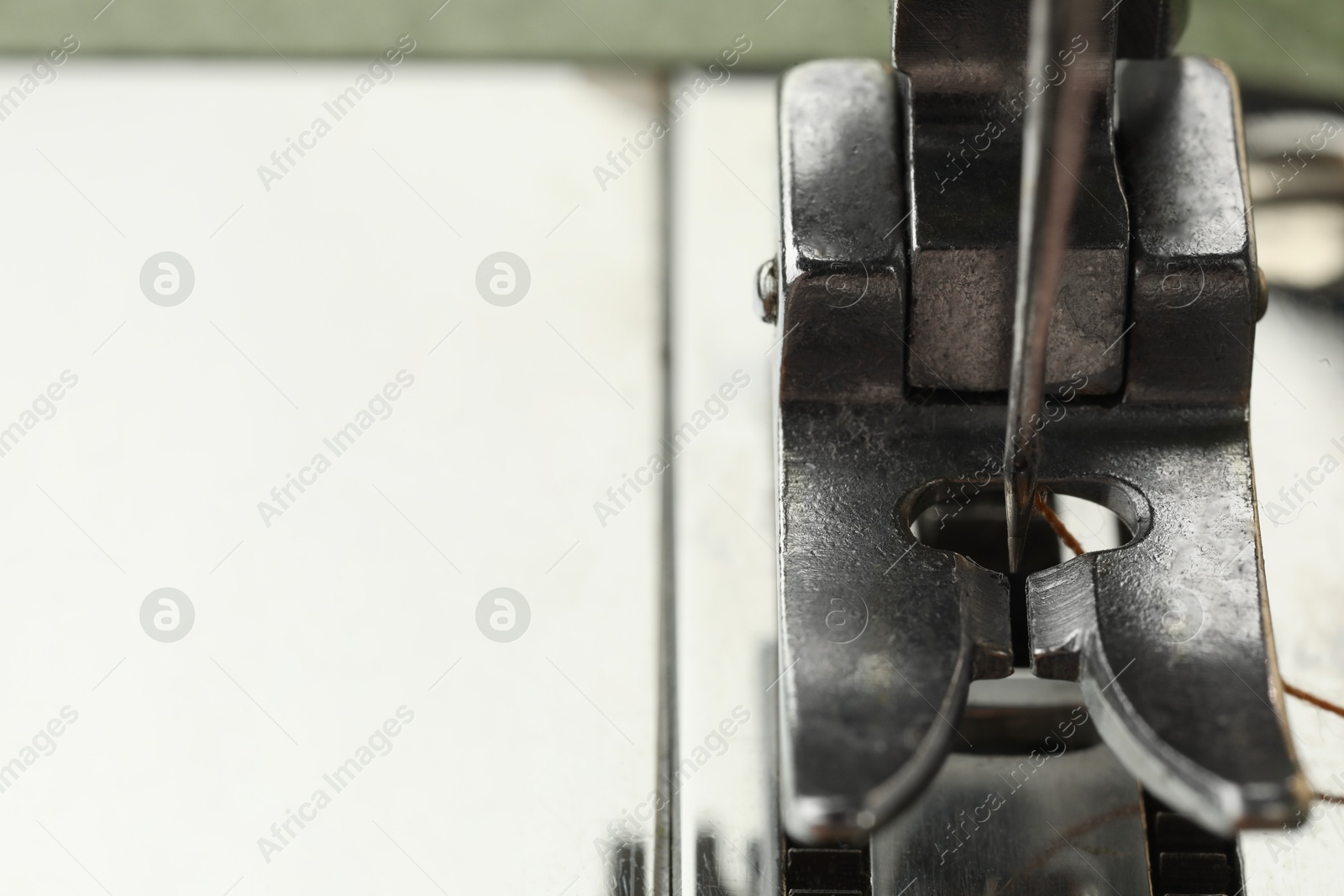 Photo of Sewing machine with thread on white background, macro view. Space for text