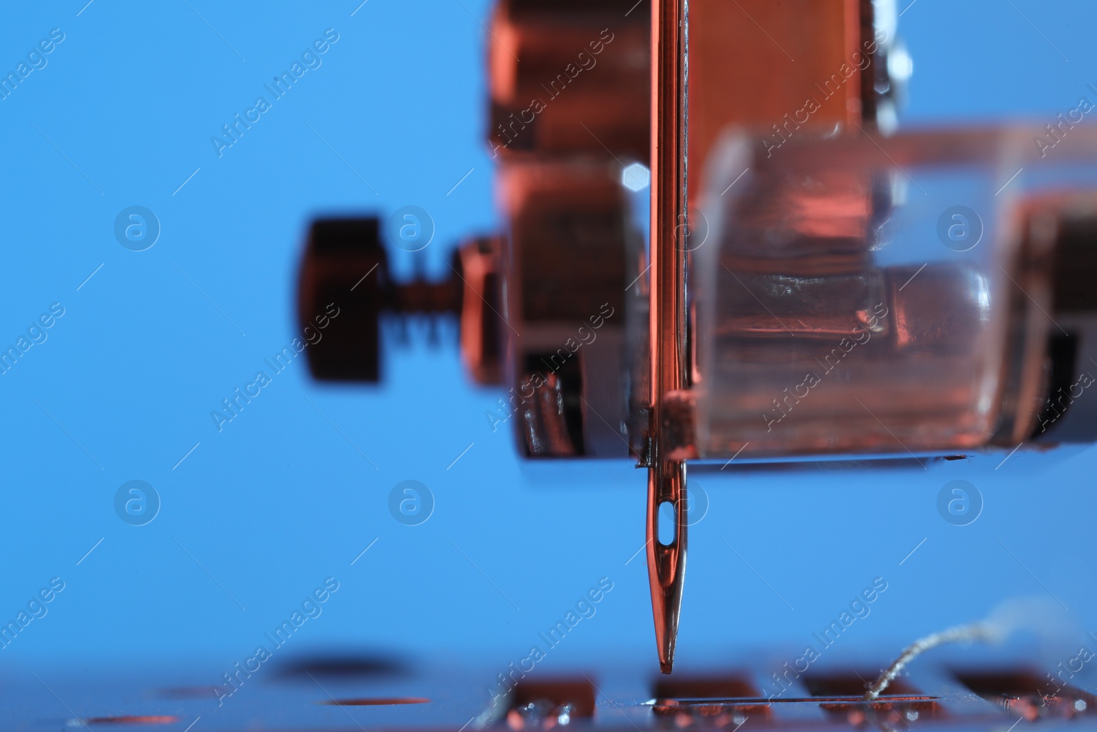 Photo of Sewing machine on light blue background, macro view