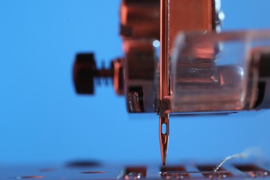 Photo of Sewing machine on light blue background, macro view