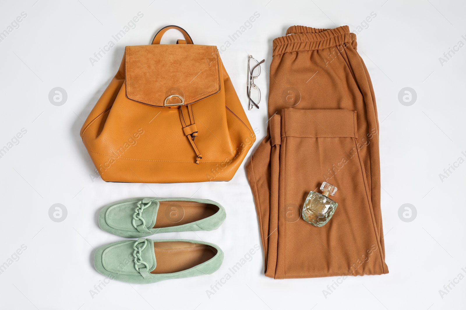 Photo of Stylish outfit with backpack on white fabric, flat lay