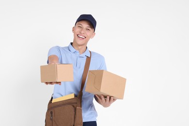 Photo of Happy postman with bag and parcels on white background